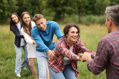 Photo of Team building. Group of happy people holding hands outdoors