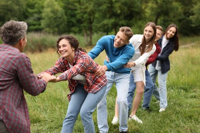 Photo of Team building. Group of happy people holding hands outdoors