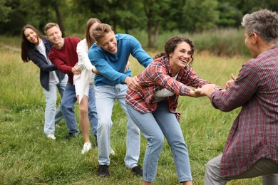 Photo of Team building. Group of happy people holding hands outdoors