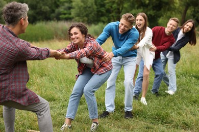 Photo of Team building. Group of happy people holding hands outdoors