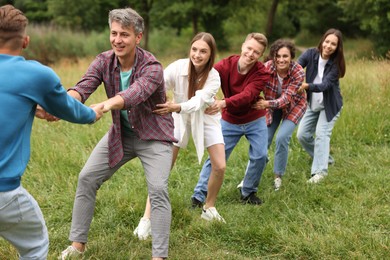 Photo of Team building. Group of happy people holding hands outdoors