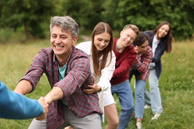 Photo of Team building. Group of happy people holding hands outdoors