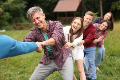 Photo of Team building. Group of happy people holding hands outdoors