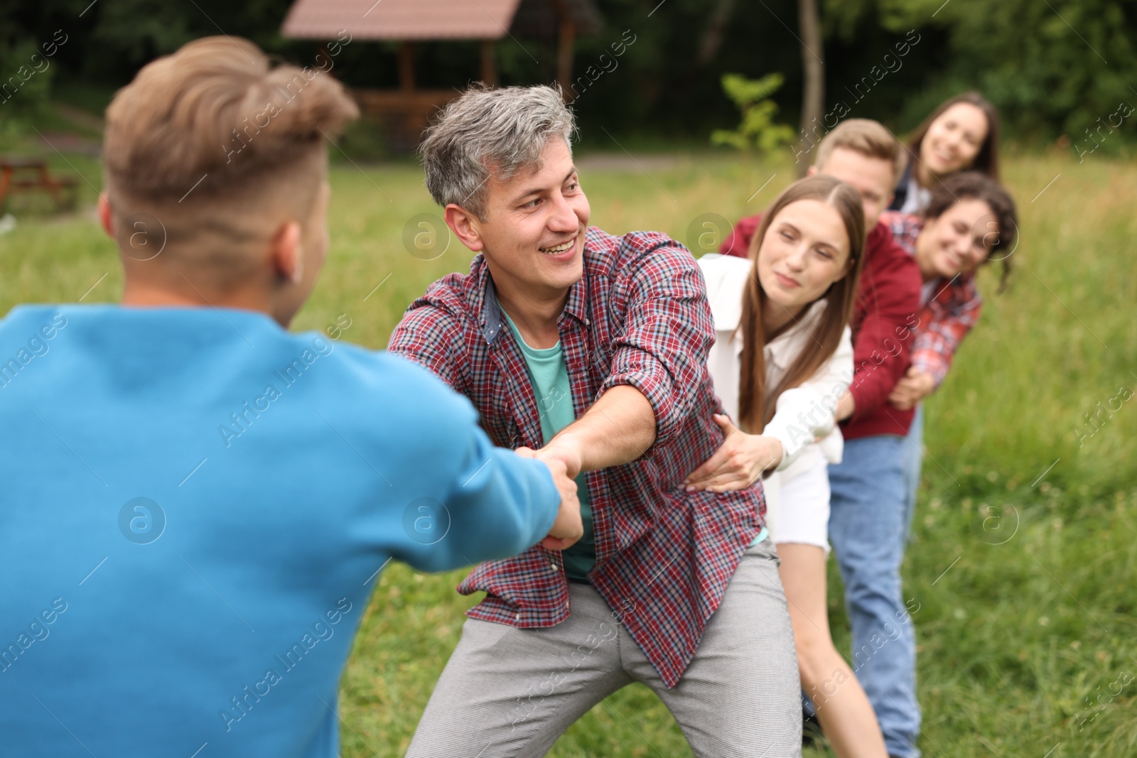 Photo of Team building. Group of happy people holding hands outdoors