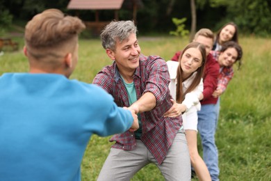 Photo of Team building. Group of happy people holding hands outdoors