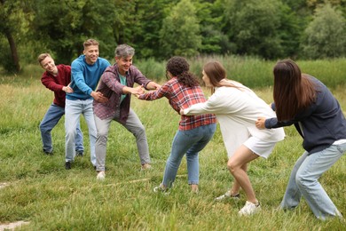 Photo of Team building. Group of happy people holding hands outdoors
