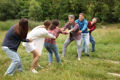 Photo of Team building. Group of happy people holding hands outdoors