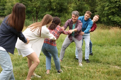 Photo of Team building. Group of happy people holding hands outdoors