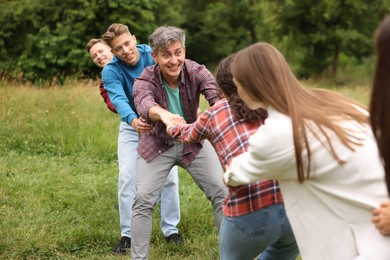 Photo of Team building. Group of happy people holding hands outdoors