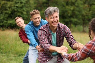 Photo of Team building. Group of happy people holding hands outdoors