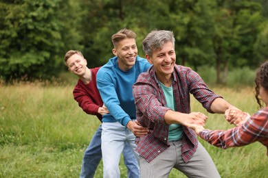 Photo of Team building. Group of happy people holding hands outdoors