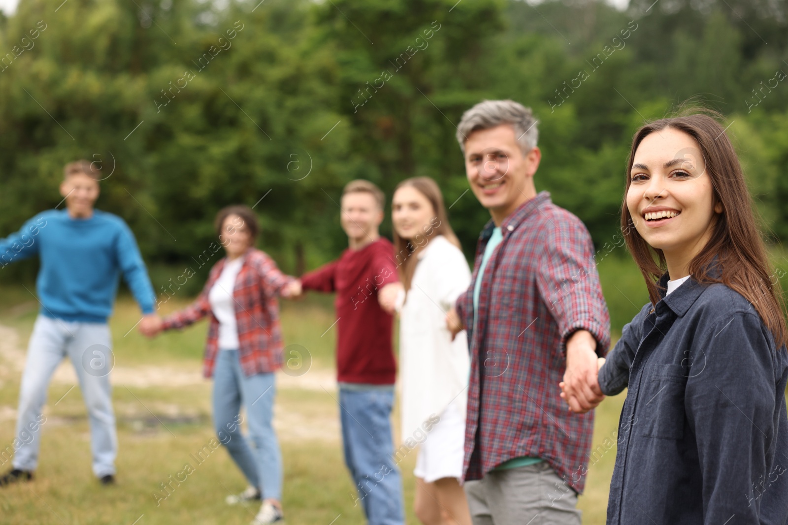 Team building. Group of happy people holding hands outdoors, selective focus Photo of Team building. Group of happy people holding hands outdoors, selective focus