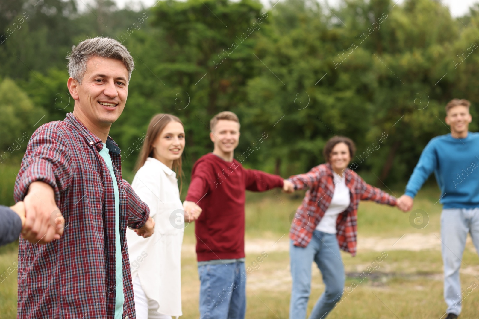 Team building. Group of happy people holding hands outdoors, selective focus Photo of Team building. Group of happy people holding hands outdoors, selective focus
