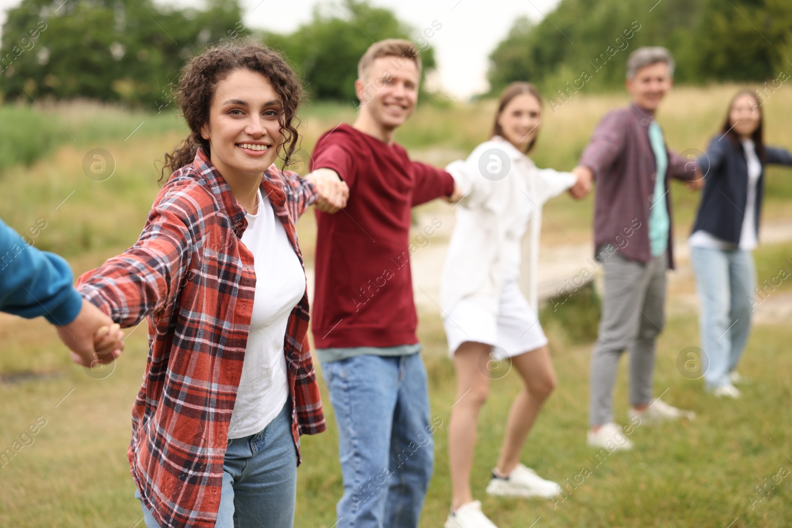 Team building. Group of happy people holding hands outdoors, selective focus Photo of Team building. Group of happy people holding hands outdoors, selective focus