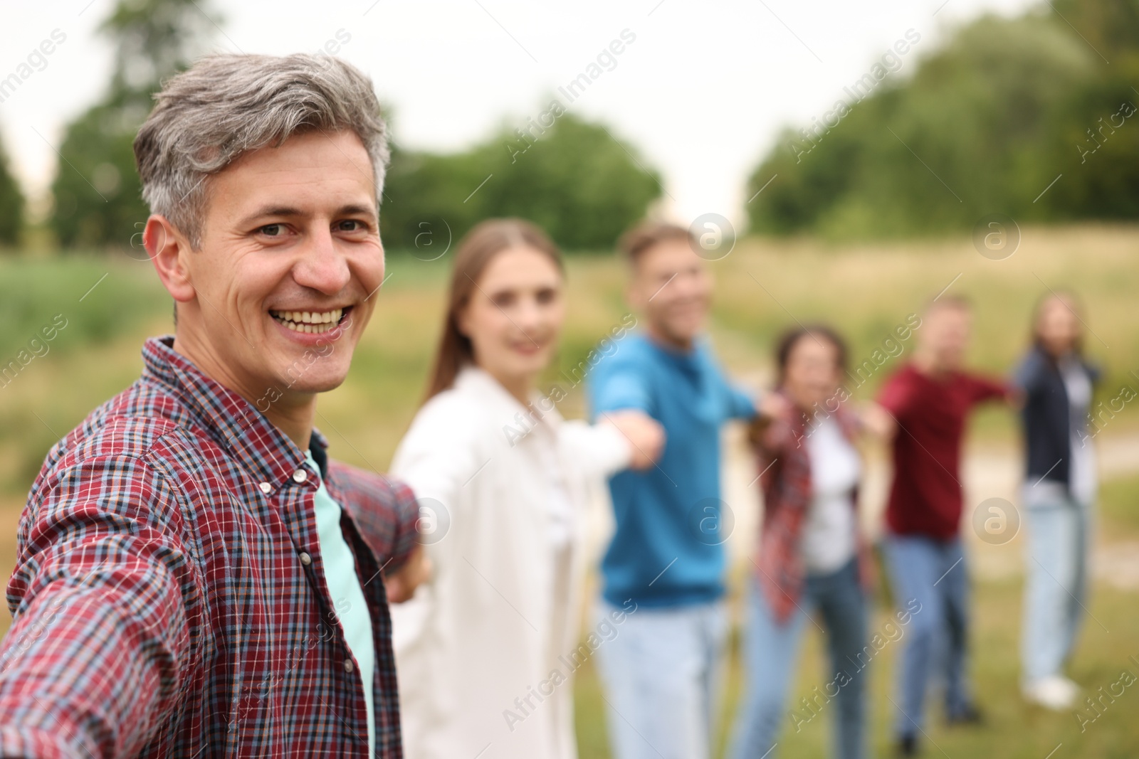 Team building. Group of happy people holding hands outdoors, selective focus Photo of Team building. Group of happy people holding hands outdoors, selective focus