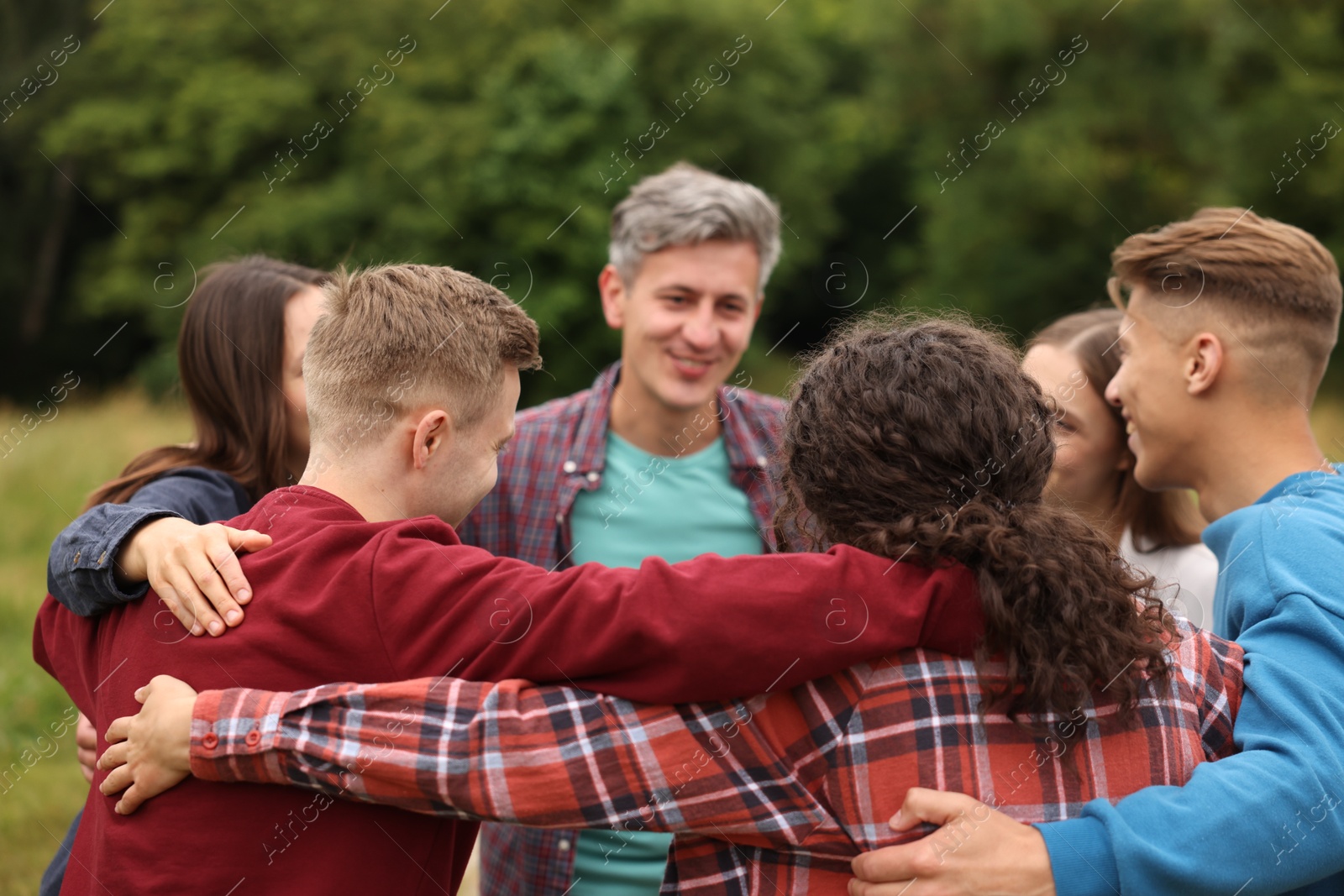 Team building. Group of happy people hugging outdoors Photo of Team building. Group of happy people hugging outdoors