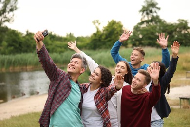 Photo of Team building. Group of happy people taking selfie outdoors