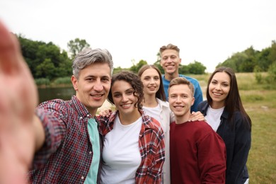 Photo of Team building. Group of happy people taking selfie outdoors