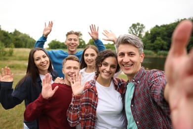 Photo of Team building. Group of happy people taking selfie outdoors