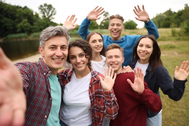 Photo of Team building. Group of happy people taking selfie outdoors