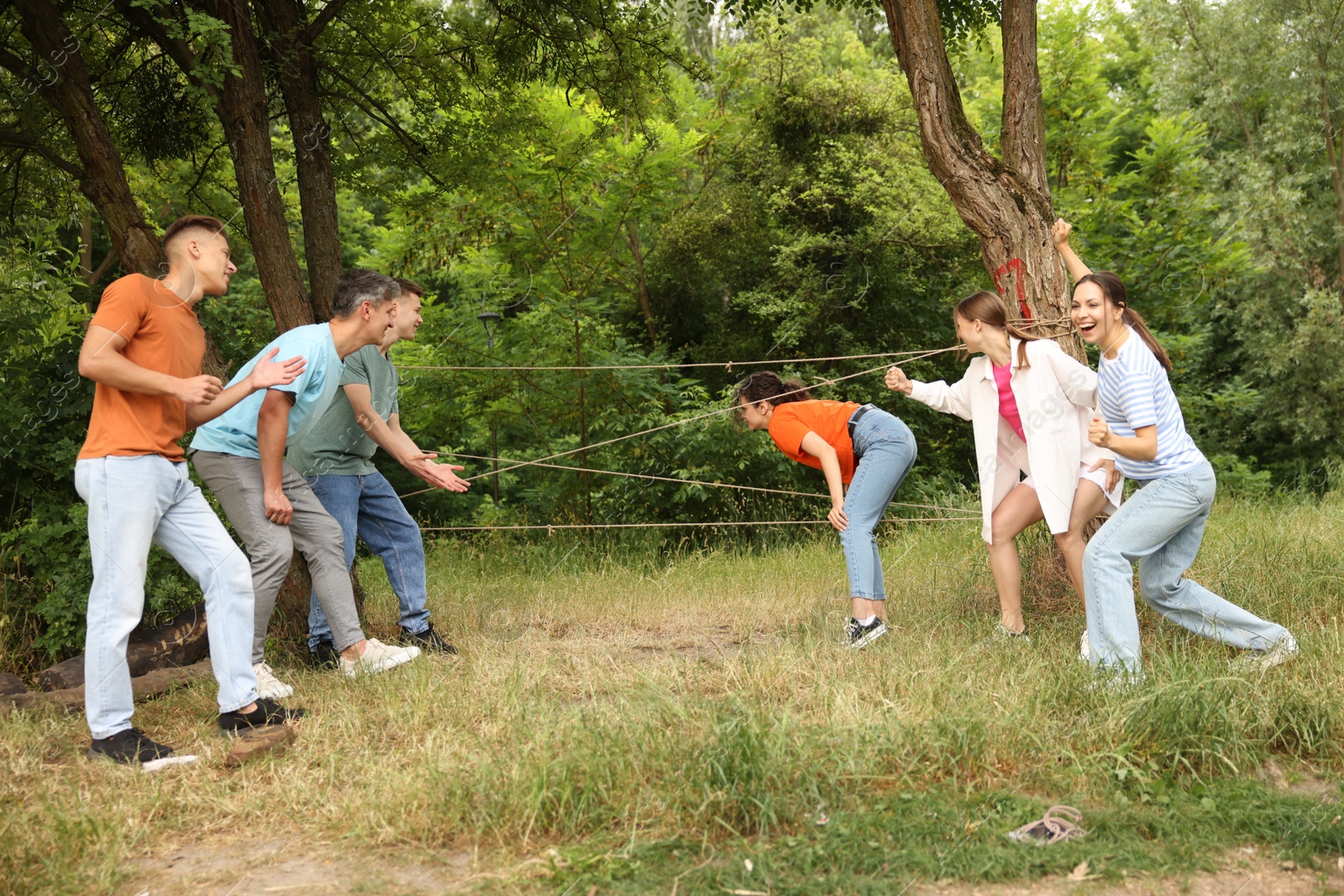 Team building. Group of happy people playing spider web game outdoors Photo of Team building. Group of happy people playing spider web game outdoors