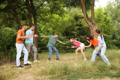 Photo of Team building. Group of happy people playing spider web game outdoors