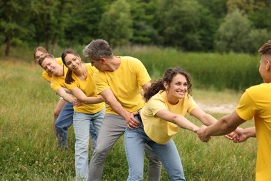 Photo of Team building. Group of happy people holding hands outdoors