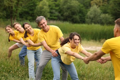Photo of Team building. Group of happy people holding hands outdoors