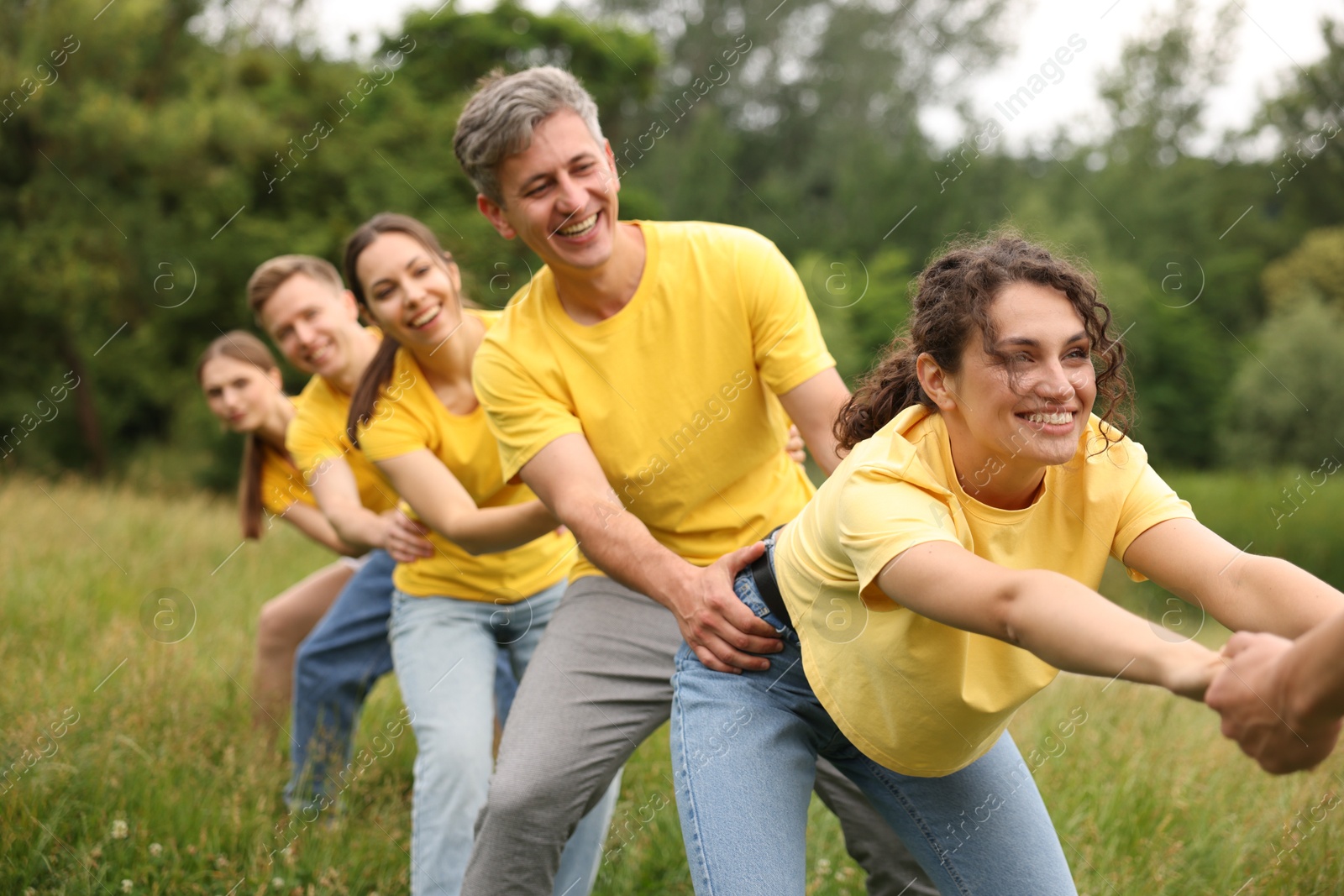 Photo of Team building. Group of happy people holding hands outdoors