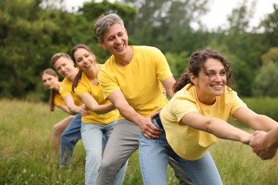 Photo of Team building. Group of happy people holding hands outdoors