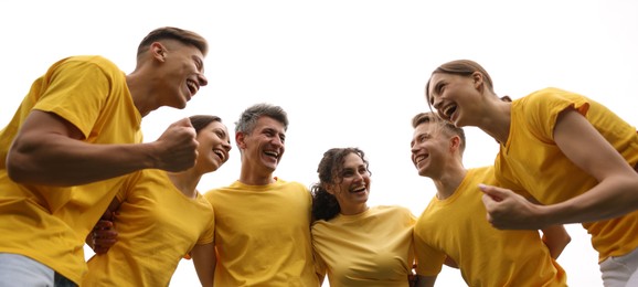 Photo of Team building. Group of happy people together outdoors, low angle view
