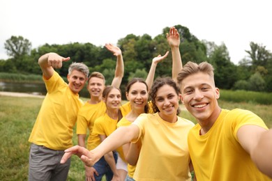 Photo of Team building. Group of happy people taking selfie outdoors