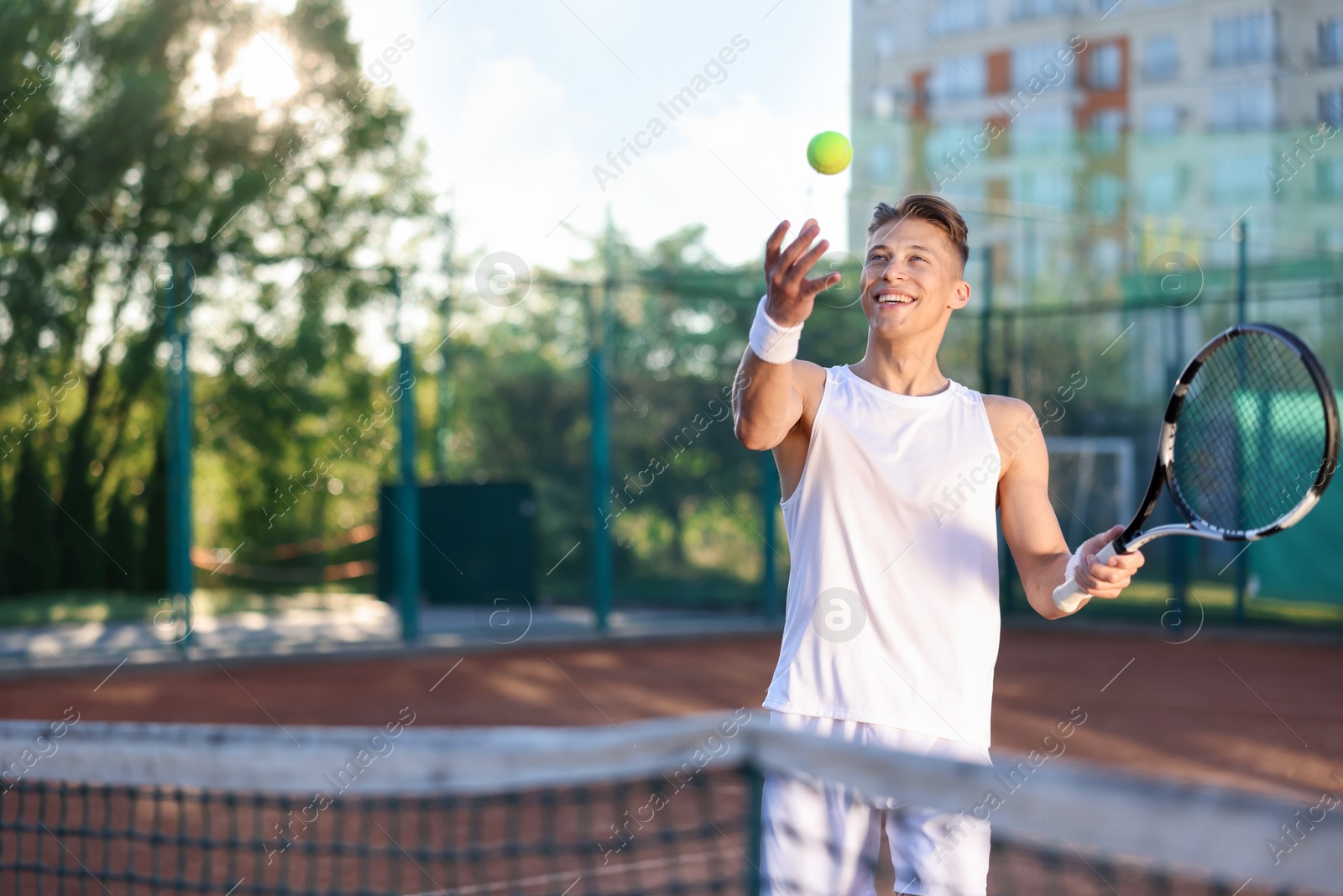 Young man playing tennis at court on sunny day. Space for text Photo of Young man playing tennis at court on sunny day. Space for text
