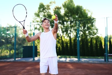Photo of Young man playing tennis at court on sunny day. Space for text