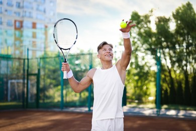 Photo of Young man playing tennis at court on sunny day