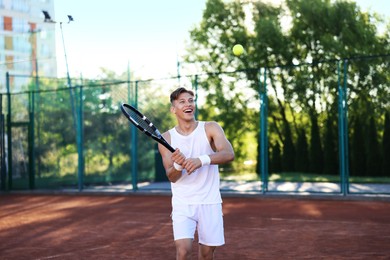 Photo of Young man playing tennis at court on sunny day