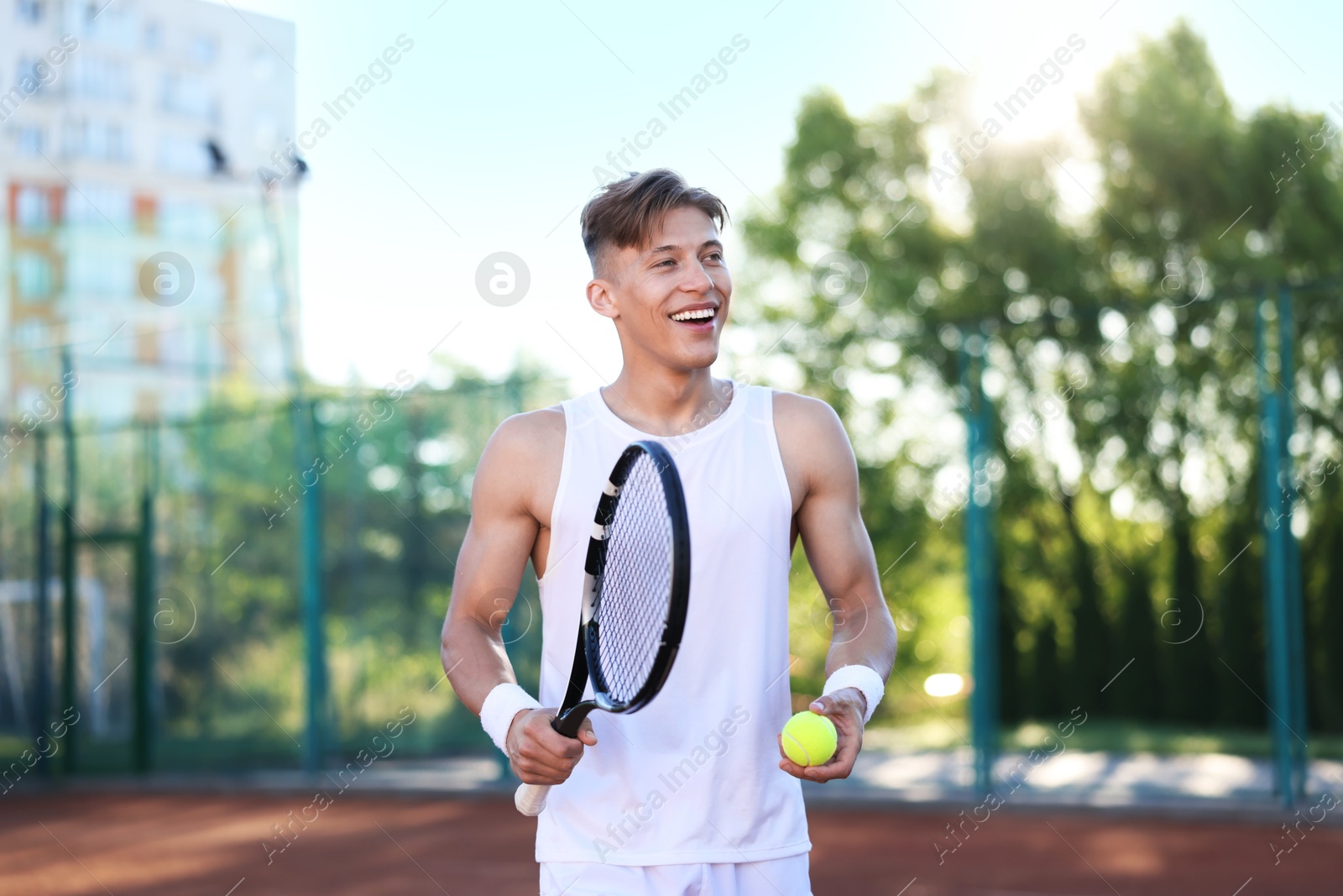 Young man playing tennis at court on sunny day Photo of Young man playing tennis at court on sunny day