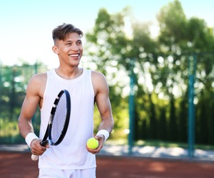 Photo of Young man playing tennis at court on sunny day. Space for text