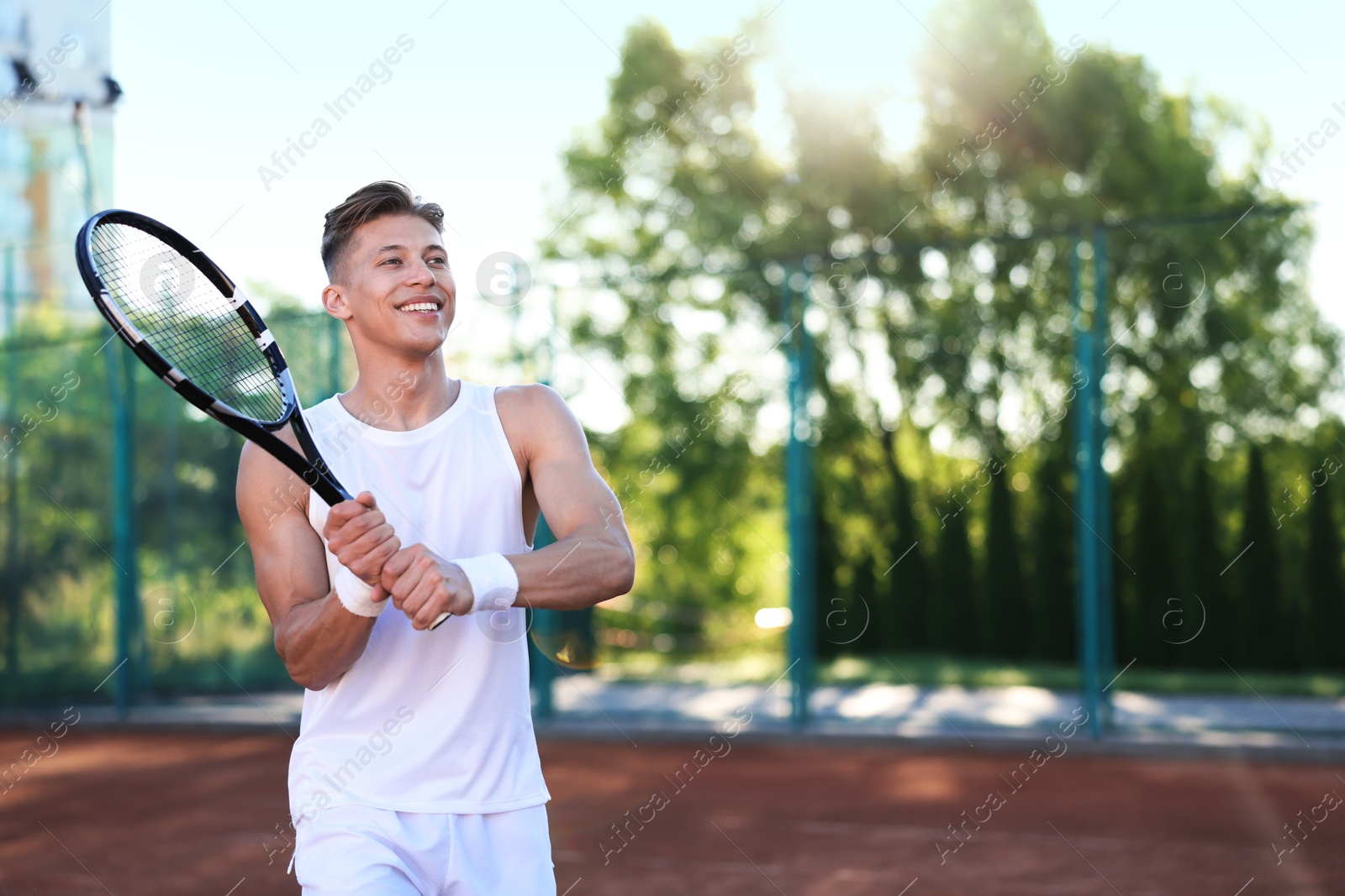 Young man playing tennis at court on sunny day. Space for text Photo of Young man playing tennis at court on sunny day. Space for text