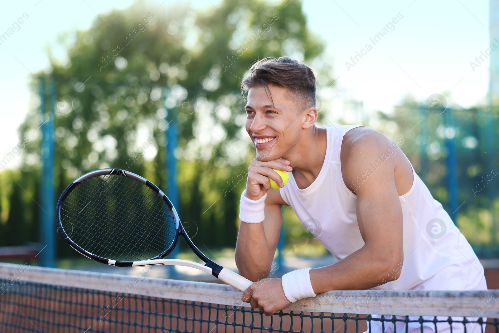 Young man with racket at tennis court Photo of Young man with racket at tennis court
