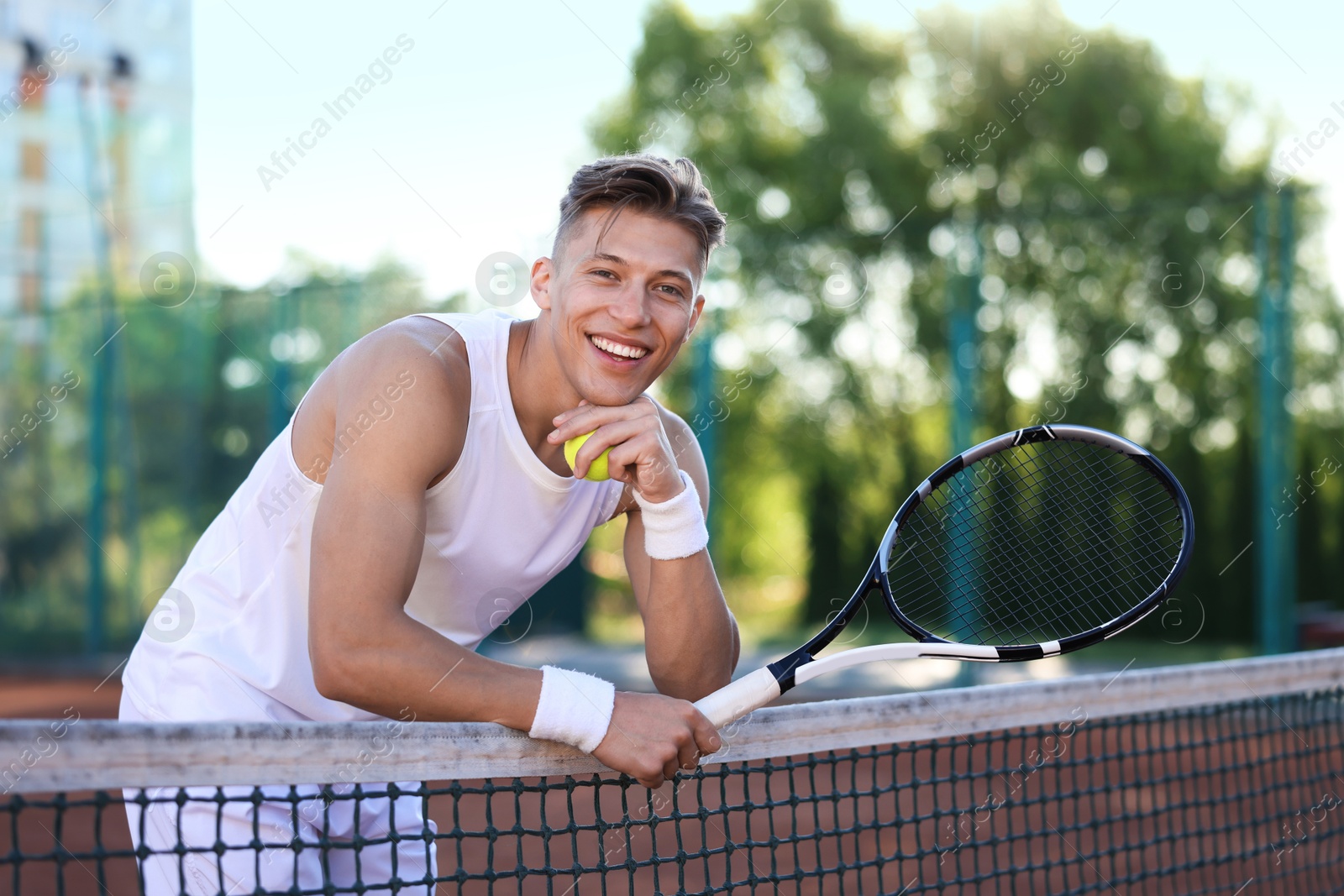 Young man with racket at tennis court Photo of Young man with racket at tennis court