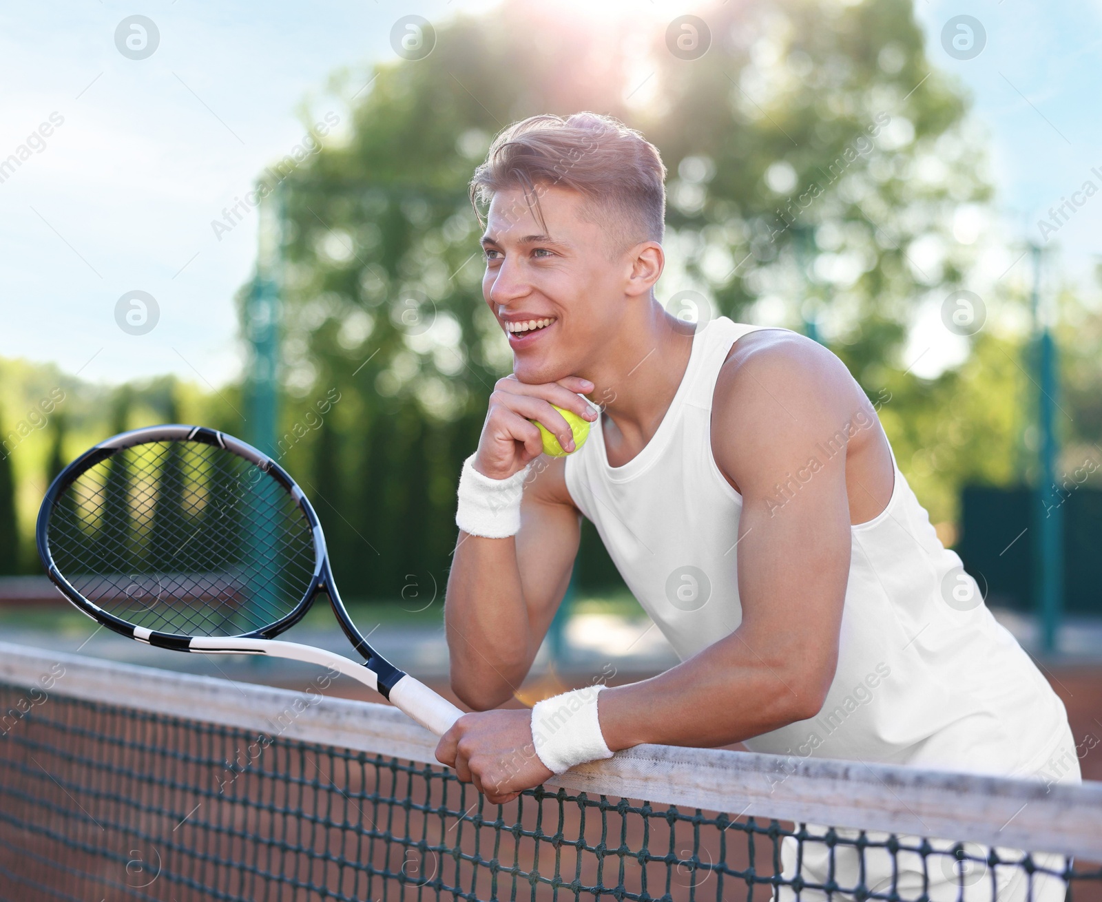 Young man with racket at tennis court Photo of Young man with racket at tennis court
