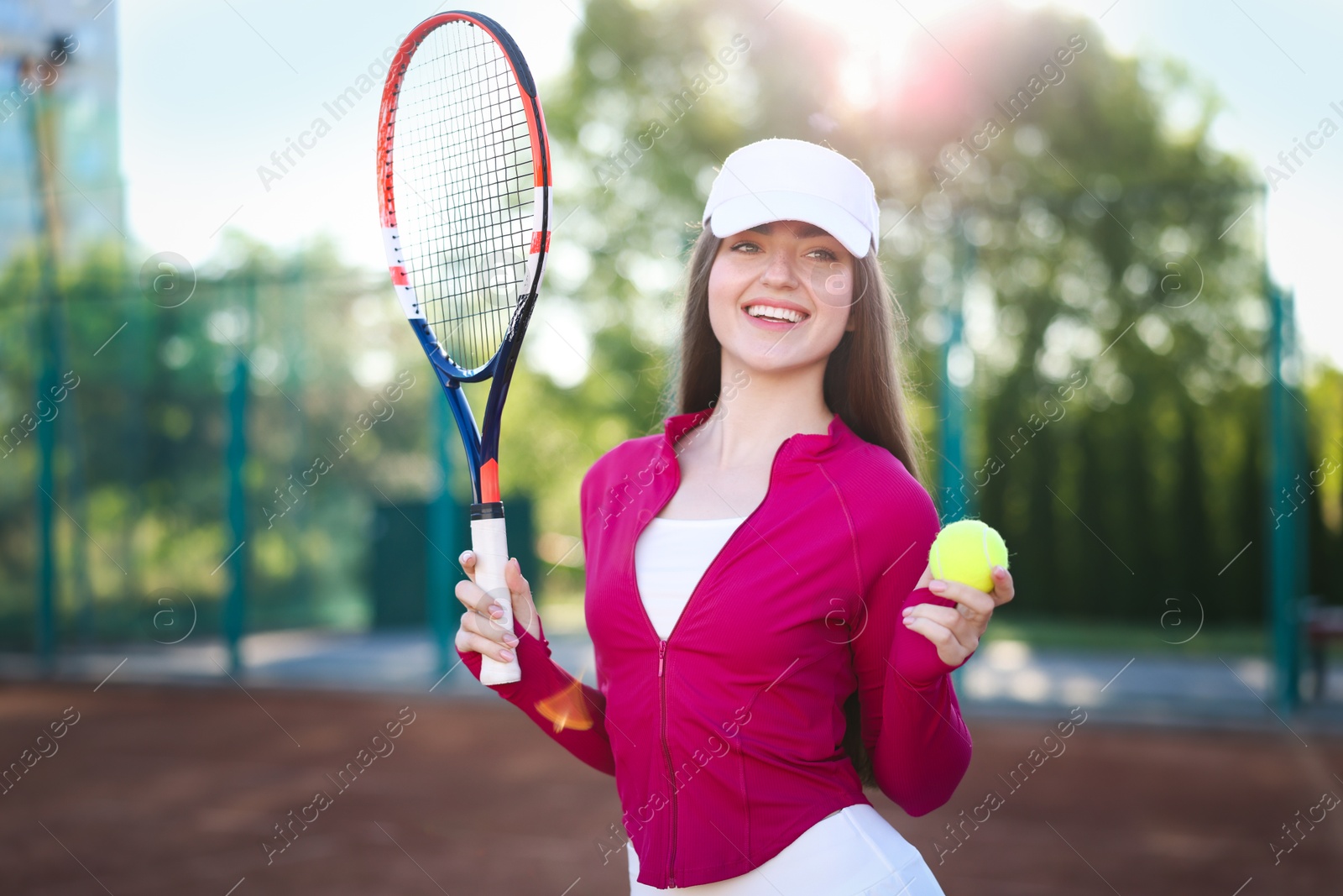 Beautiful woman with racket and ball at tennis court Photo of Beautiful woman with racket and ball at tennis court