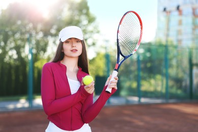 Photo of Beautiful woman with racket and ball at tennis court
