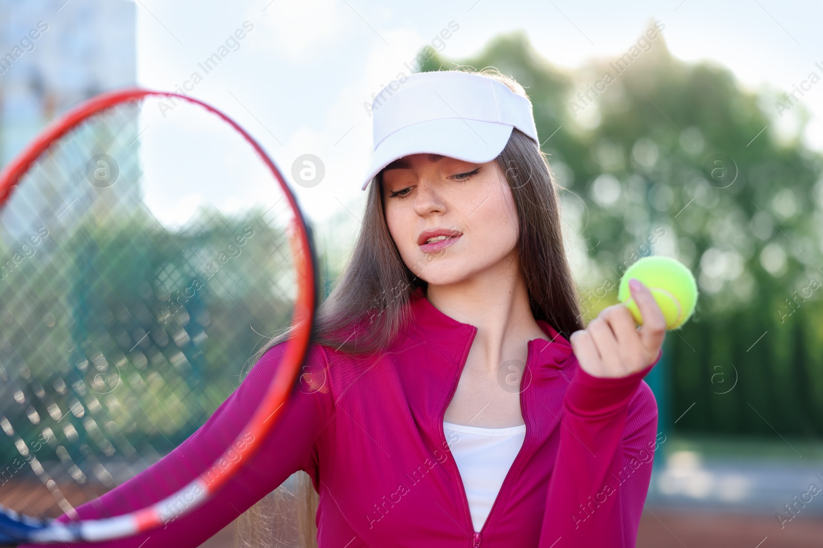 Beautiful woman with racket and ball at tennis court Photo of Beautiful woman with racket and ball at tennis court