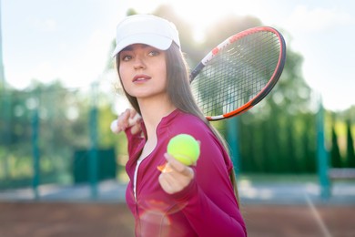Photo of Beautiful woman with racket and ball at tennis court
