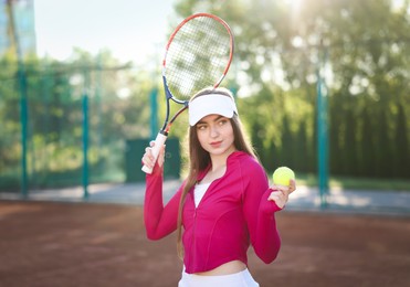 Photo of Beautiful woman with racket and ball at tennis court
