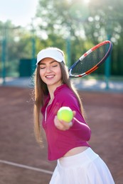 Photo of Beautiful woman with racket and ball at tennis court
