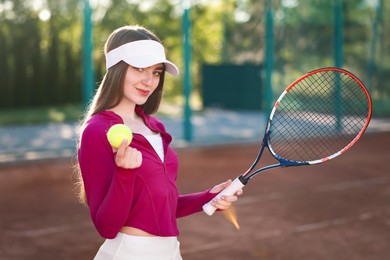 Photo of Beautiful woman with racket and ball at tennis court