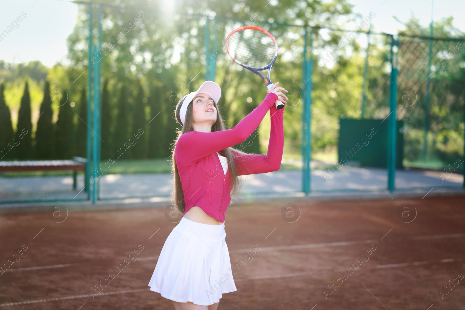 Beautiful woman playing tennis at court on sunny day Photo of Beautiful woman playing tennis at court on sunny day